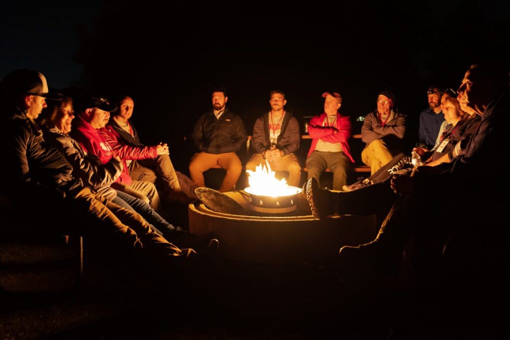 Men and women at a campfire.