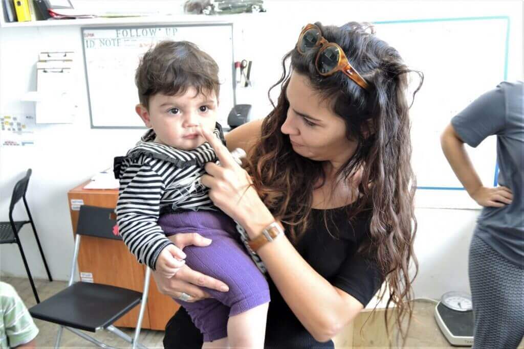 Katerina providing patient care and levity to a young child. 