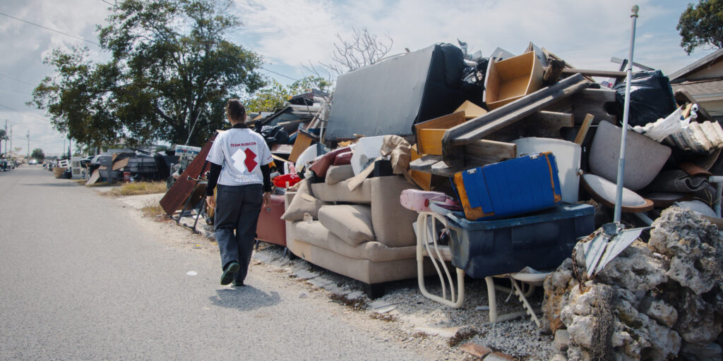 hurricane relief volunteer near debris