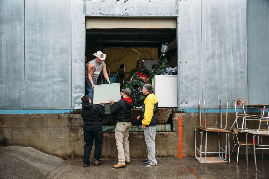 volunteers remove junk donations from a community center that were causing the second disaster