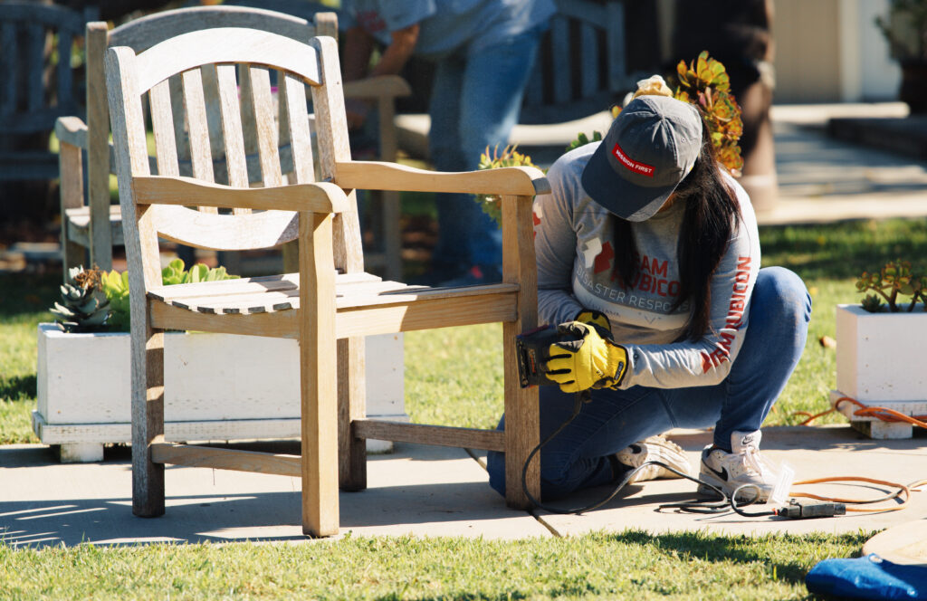 volunteer sanding chair at youth center to celebrate Go Day